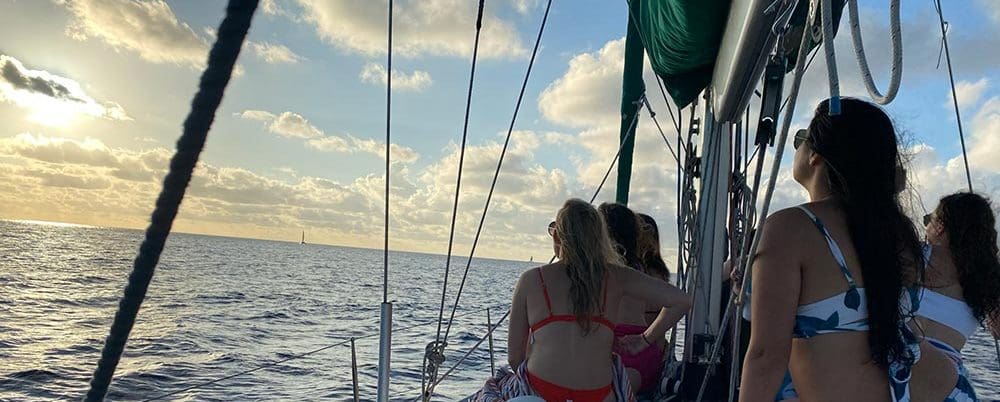 Two women on a boat looking out at the ocean.