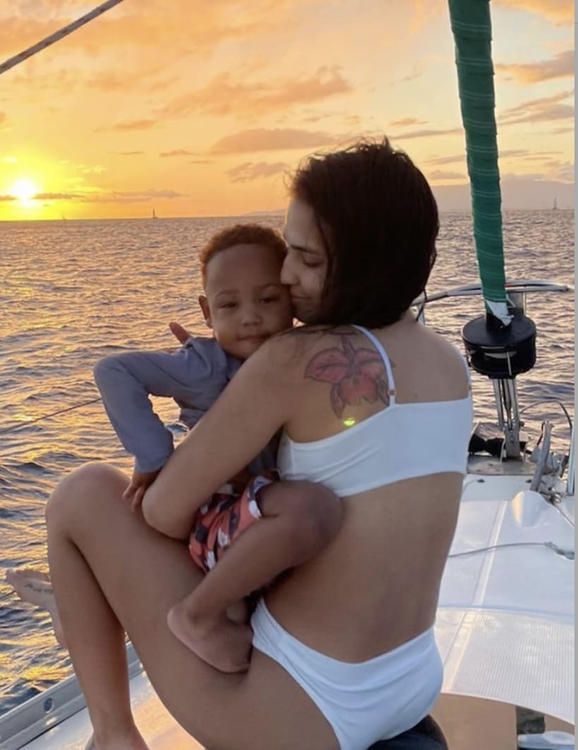A woman and child on a boat at sunset.