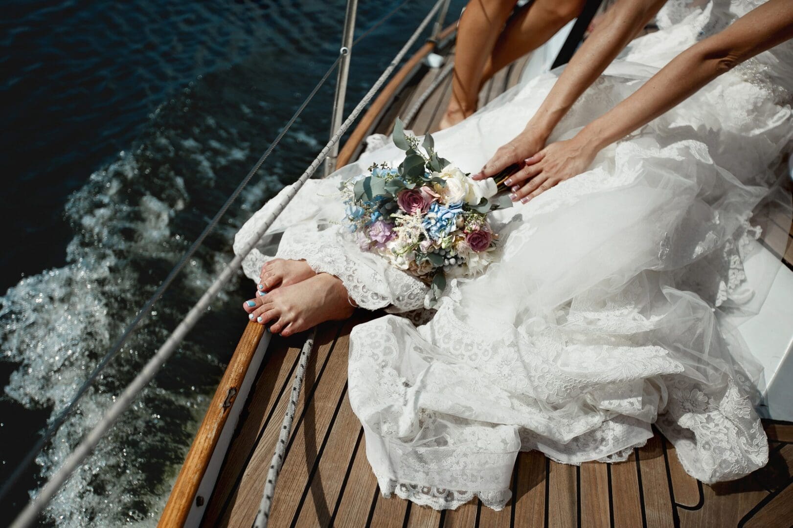 A bride and groom on the deck of their boat.