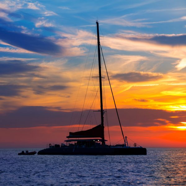 A boat is sailing in the ocean at sunset.