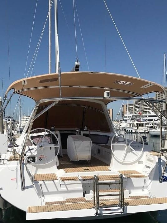 A boat with a large wooden deck and steering wheel.